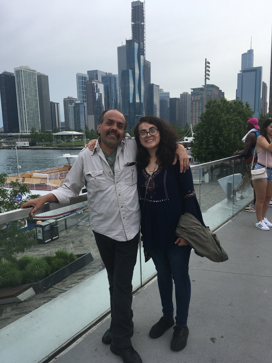 Maritza and her father standing together by the waterfront.